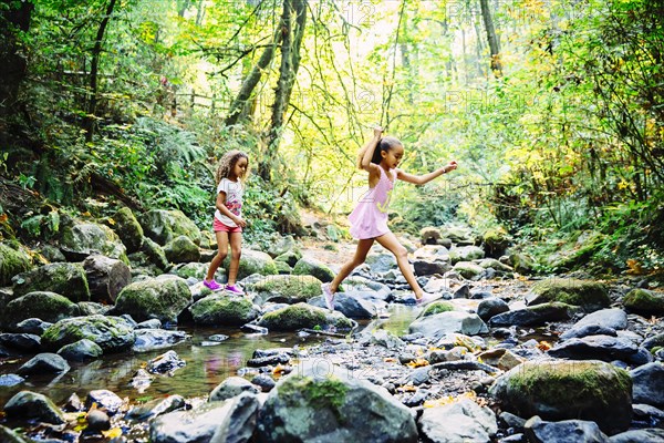 Mixed race sisters exploring stream