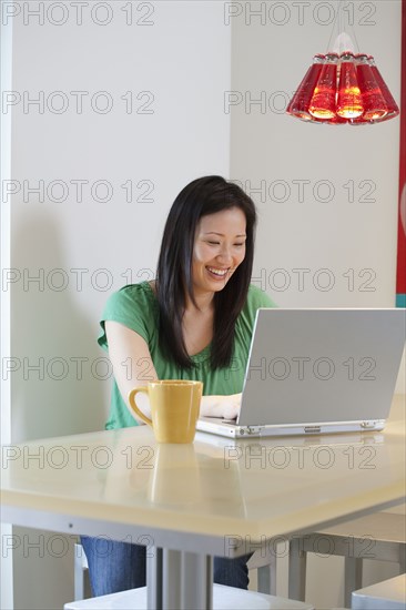 Korean woman typing on laptop