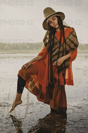 Caucasian woman wearing traditional clothing wading in water