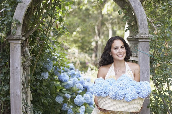 Young woman carrying a basket of flowers