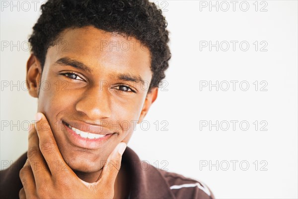 African man rubbing chin and smiling