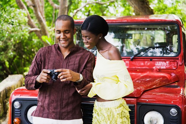 African couple looking down at digital camera