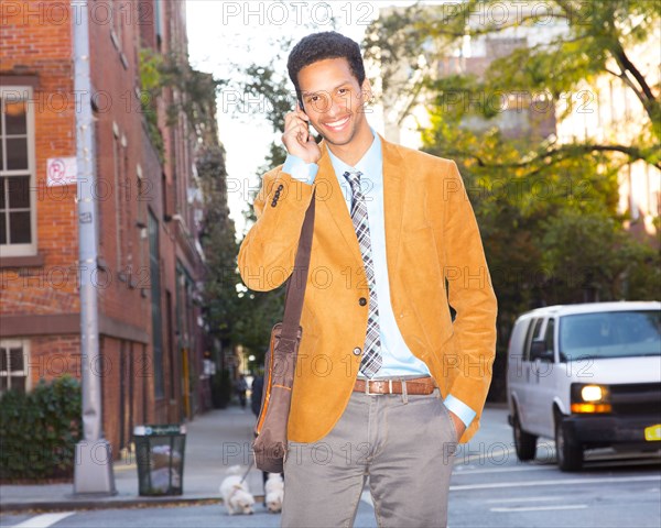 Mixed race businessman talking on cell phone outdoors