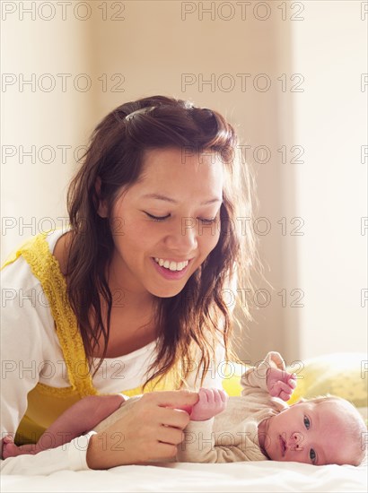 Mother playing with newborn baby