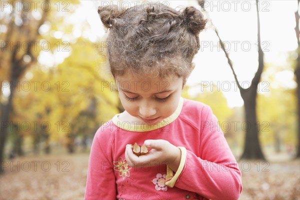 Hispanic girl examining plants outdoors