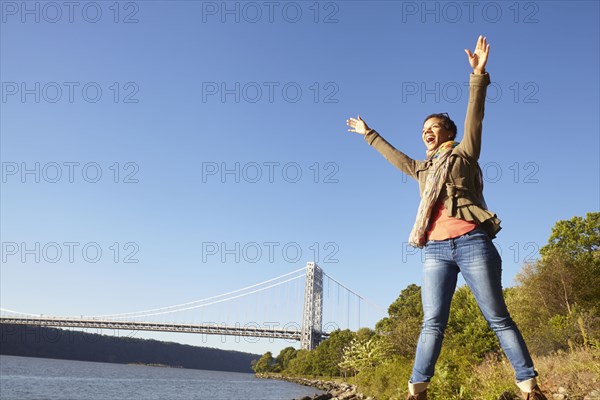 Black woman cheering by river