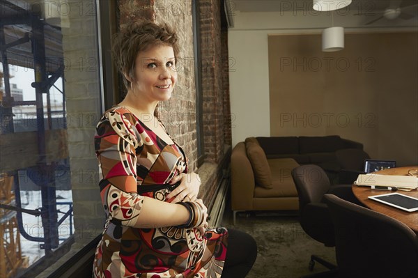 Pregnant businesswoman smiling in office