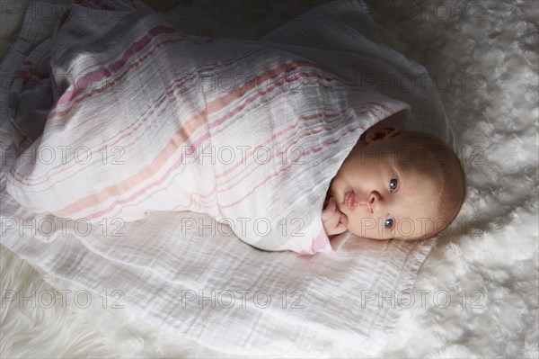 Newborn baby swaddled in blanket