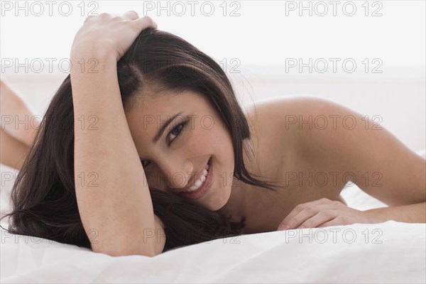 Alluring mixed race woman laying in bed