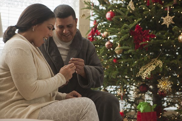 Couple opening gifts on Christmas morning