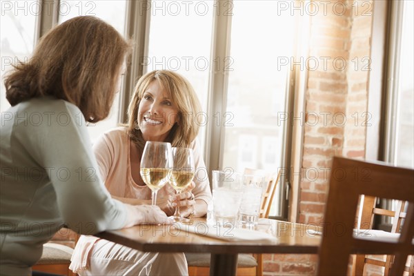 Caucasian friends drinking wine in restaurant