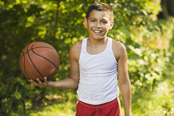 Mixed race boy holding basketball