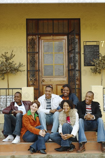 Multi-ethnic friends sitting on porch steps
