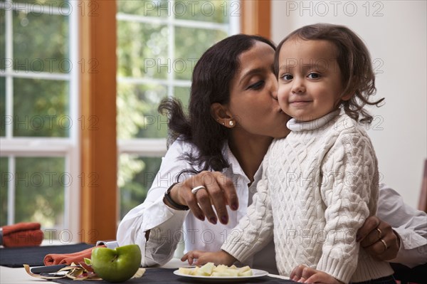 Indian mother kissing daughter