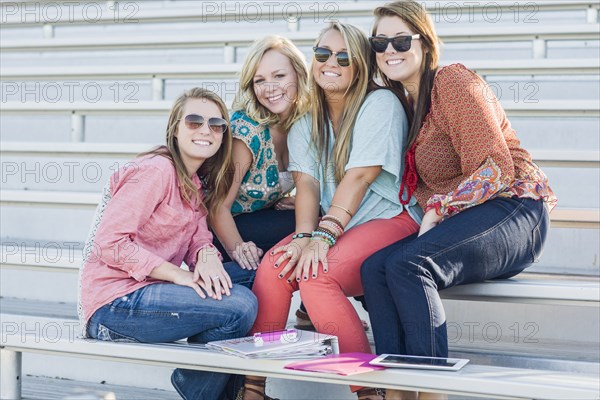 Friends sitting on bleachers