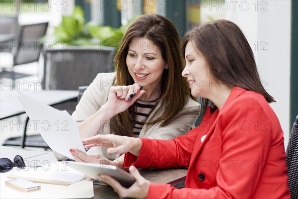 Caucasian businesswomen working in cafe