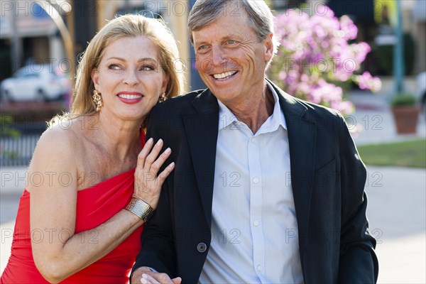 Older Caucasian couple hugging outdoors