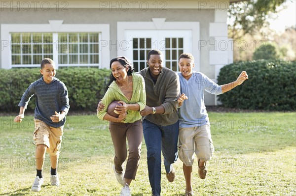 Family playing football in backyard