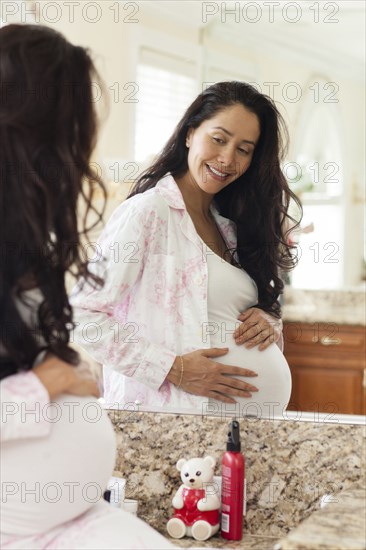 Pregnant Hispanic woman holding her belly