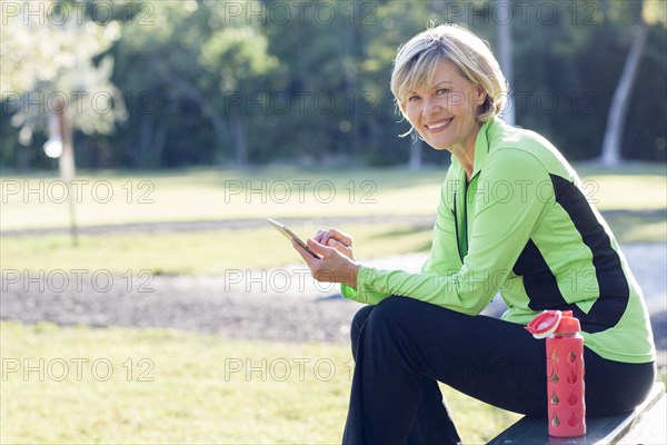 Caucasian woman using digital tablet in park