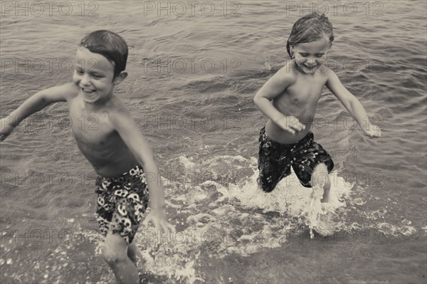 Caucasian boys playing in lake