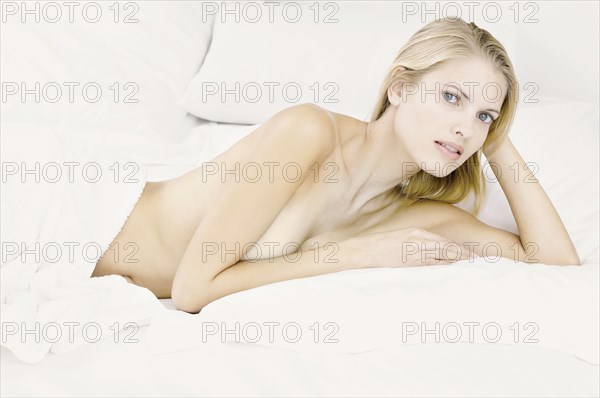 Nude woman laying in bed