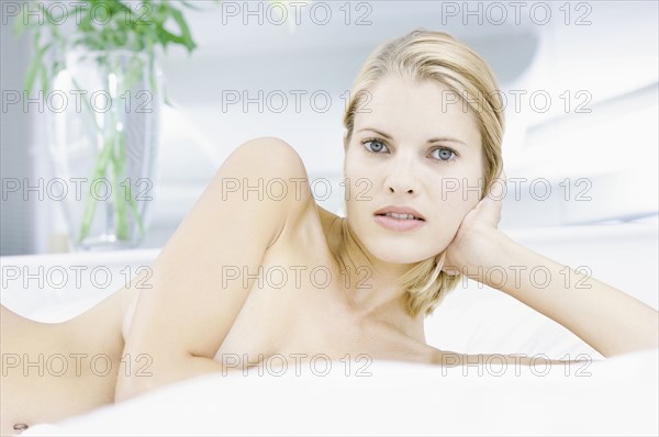 Nude woman laying on bed