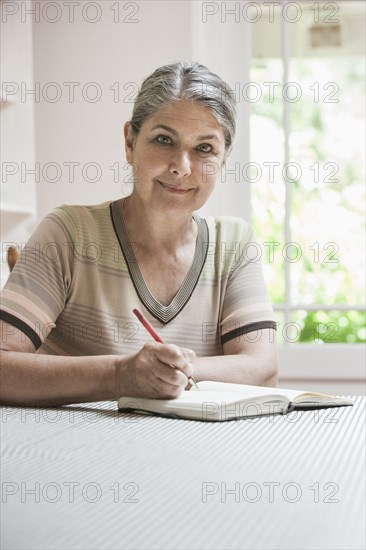 Caucasian woman writing in journal