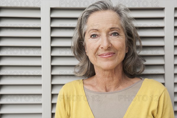 Woman smiling by shutters