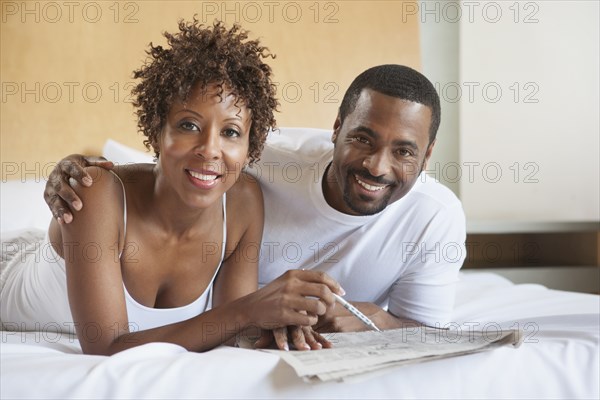 African American couple reading in bed