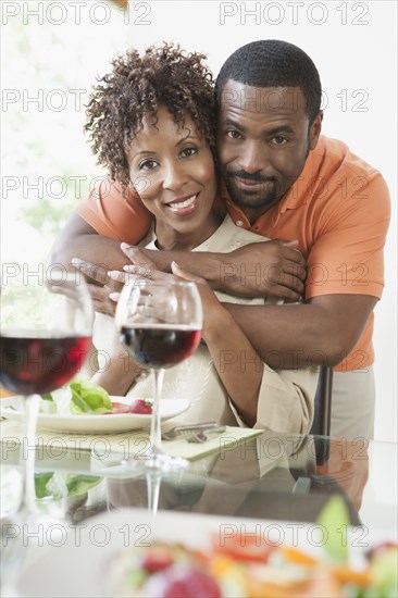 African American couple hugging at dinner table