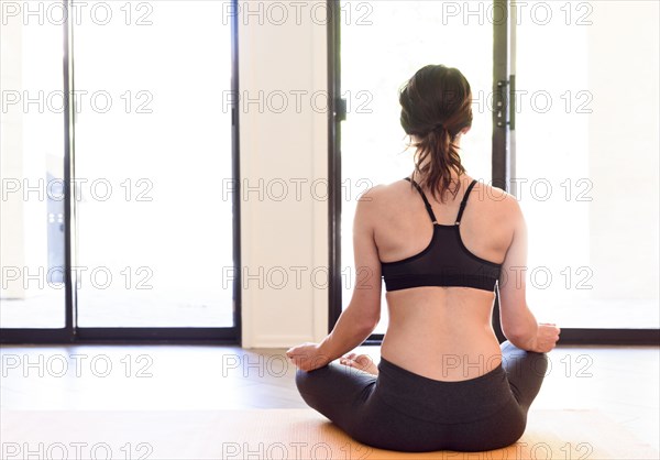 Caucasian woman performing yoga and meditating