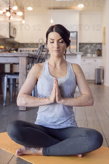 Caucasian woman performing yoga and meditating