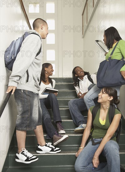 Group of friends sitting on stairs at school