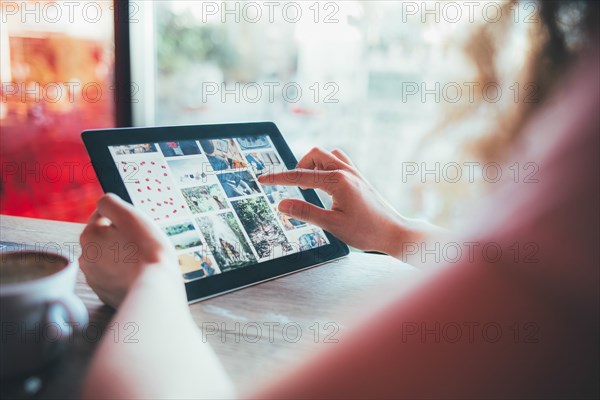 Woman using tablet computer in cafe