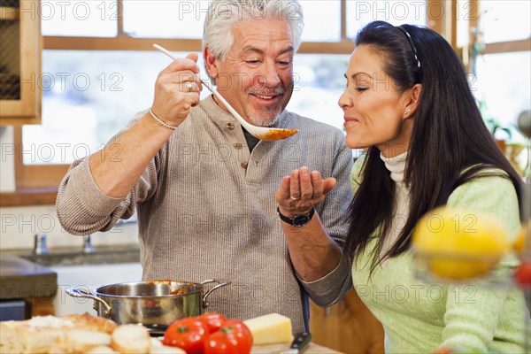 Hispanic couple cooking together in kitchen