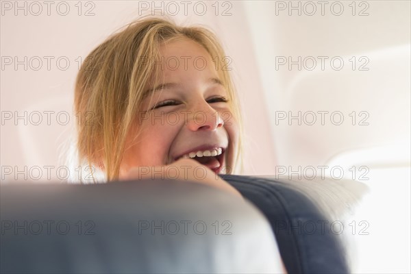 Caucasian girl laughing on airplane