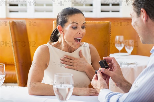 Man proposing to girlfriend at restaurant