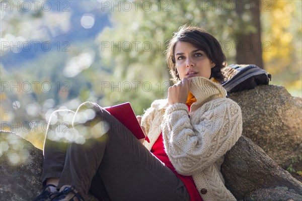 Mixed race hiker reading in forest