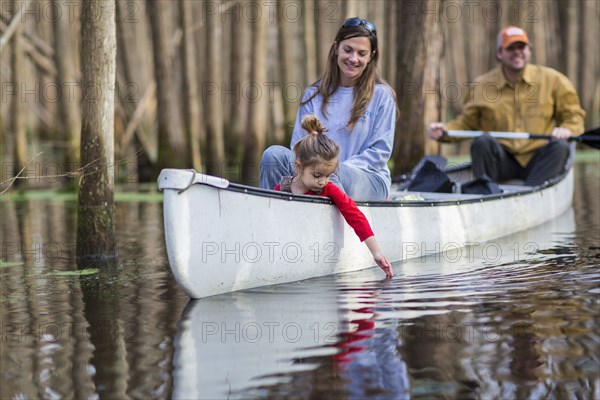 Family sitting together in canoe on river