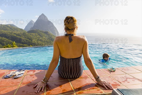 Caucasian mother watching son swimming