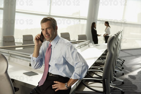 Businessman talking on cell phone in conference room