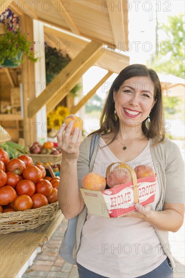 Hispanic woman holding produce at farmers market