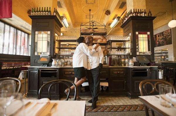 Chef and waitress hugging in restaurant