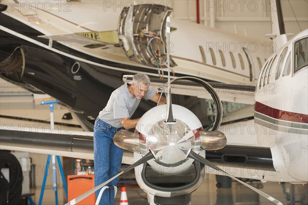 Caucasian man working in airplane hangar
