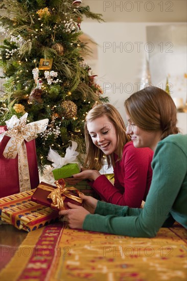 Caucasian women opening Christmas gifts