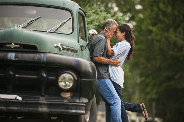 Couple kissing by truck outdoors