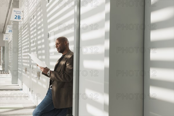 African American businessman reading papers in office