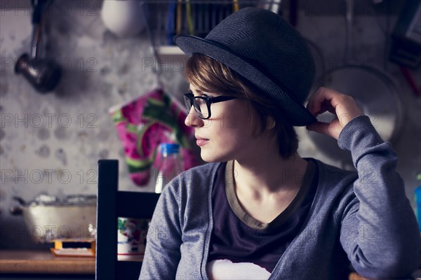 Caucasian woman wearing hat and eyeglasses in kitchen