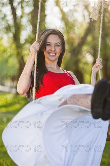 Caucasian woman swinging on swing